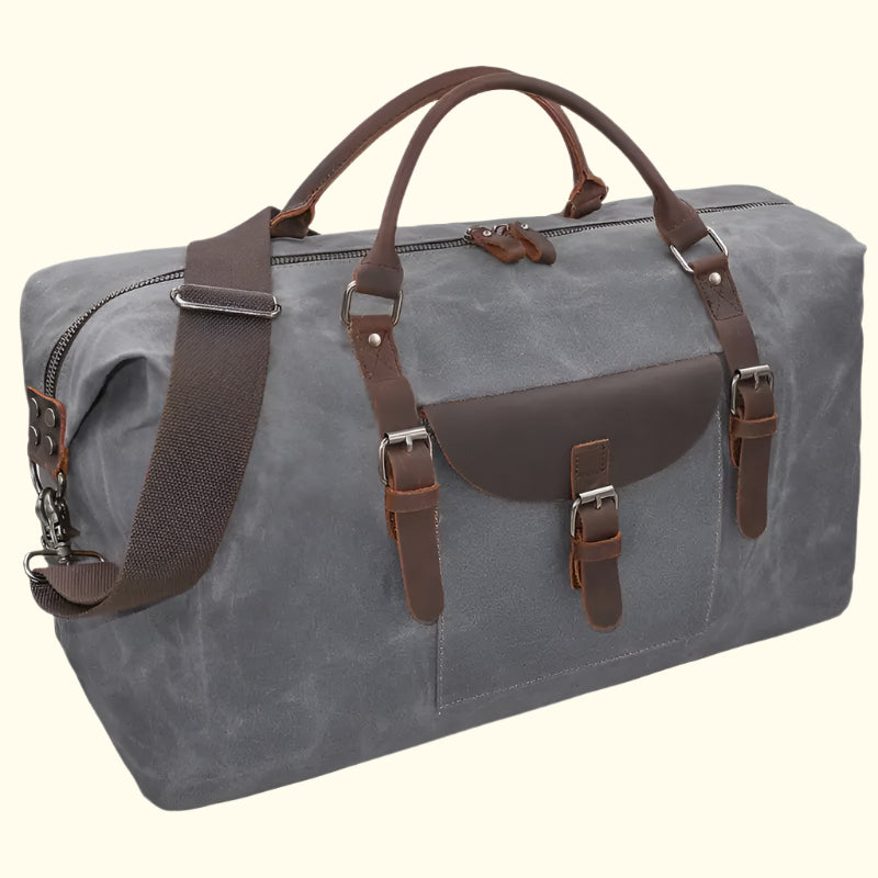 Gray duffel bag with brown leather straps on a white background