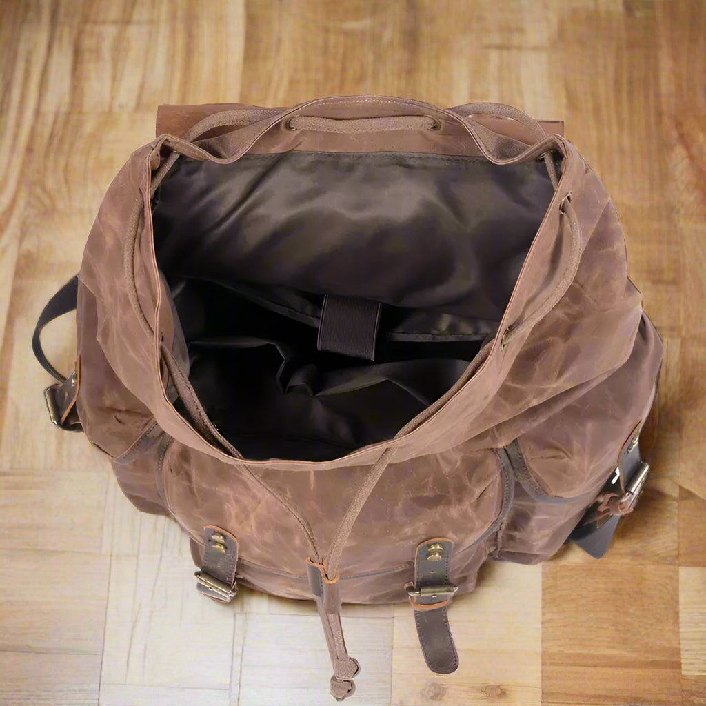 Brown leather backpack on a wooden floor