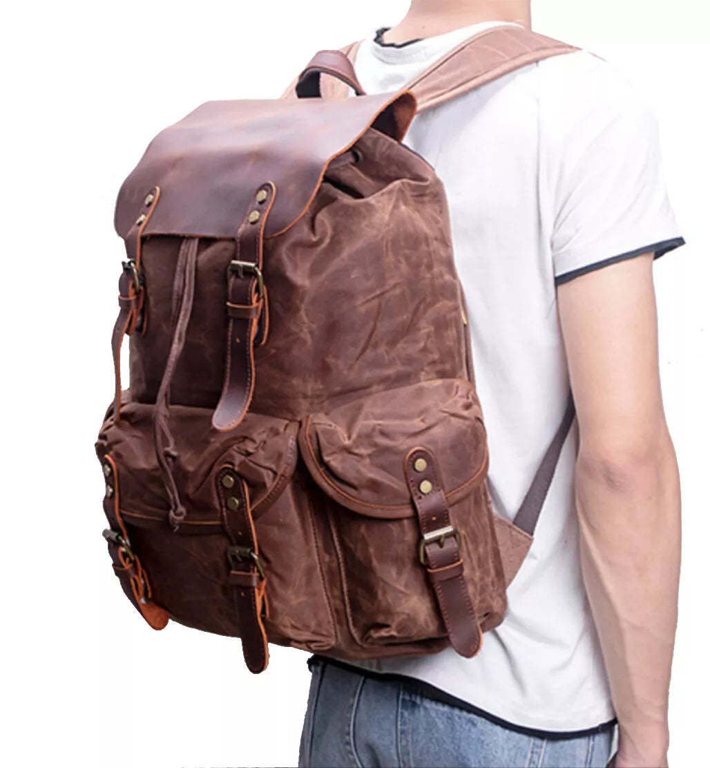 Brown leather backpack worn by a person on a white background