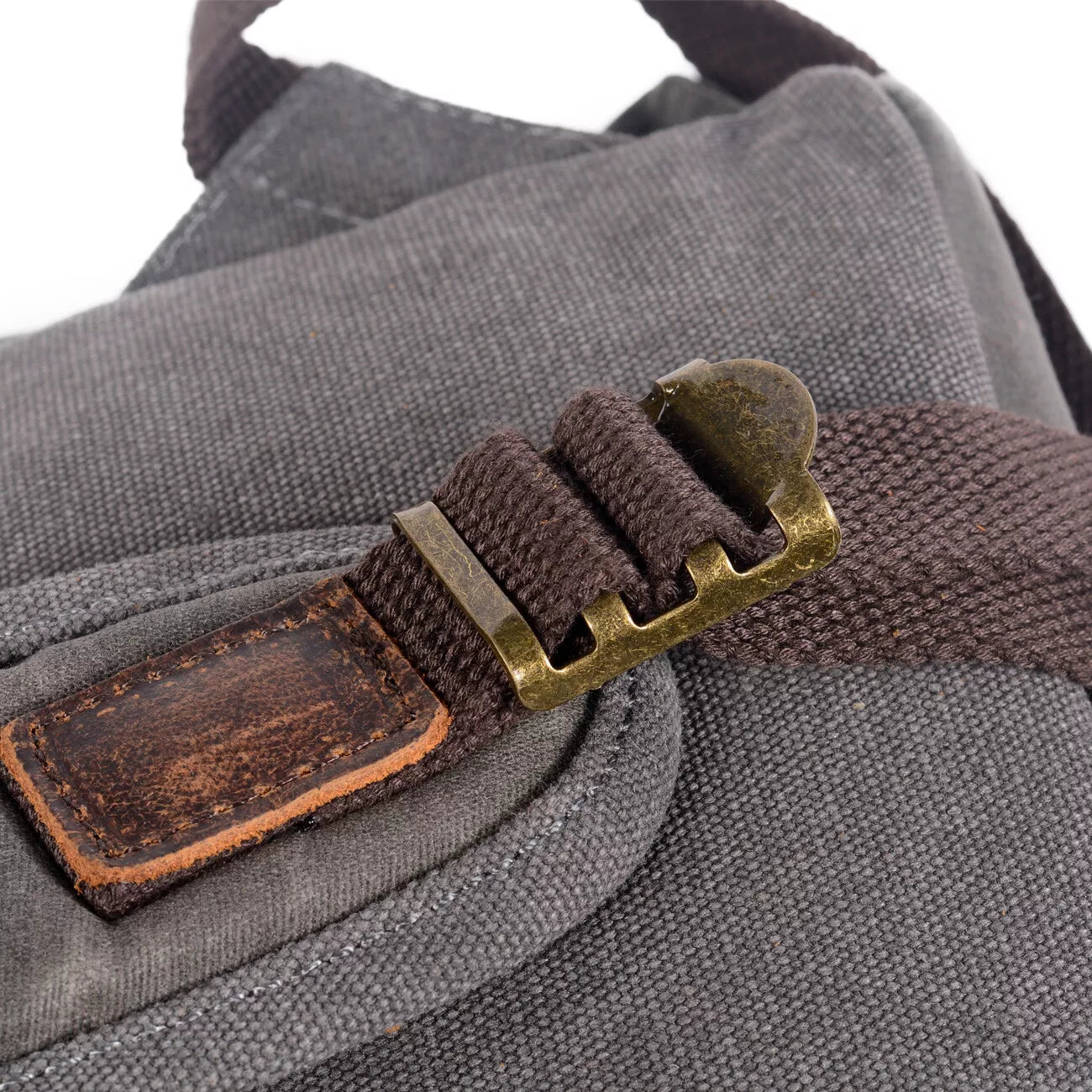 Close-up of a gray bag with a brown strap and metal buckle on a white background